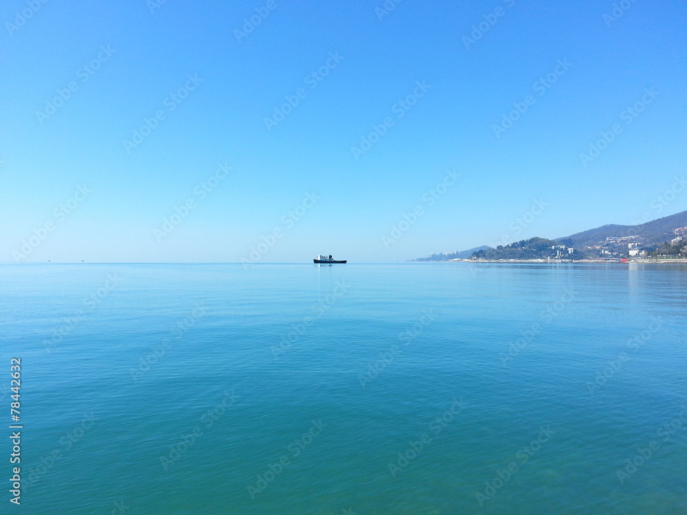 Small ship sails on the blue sea water