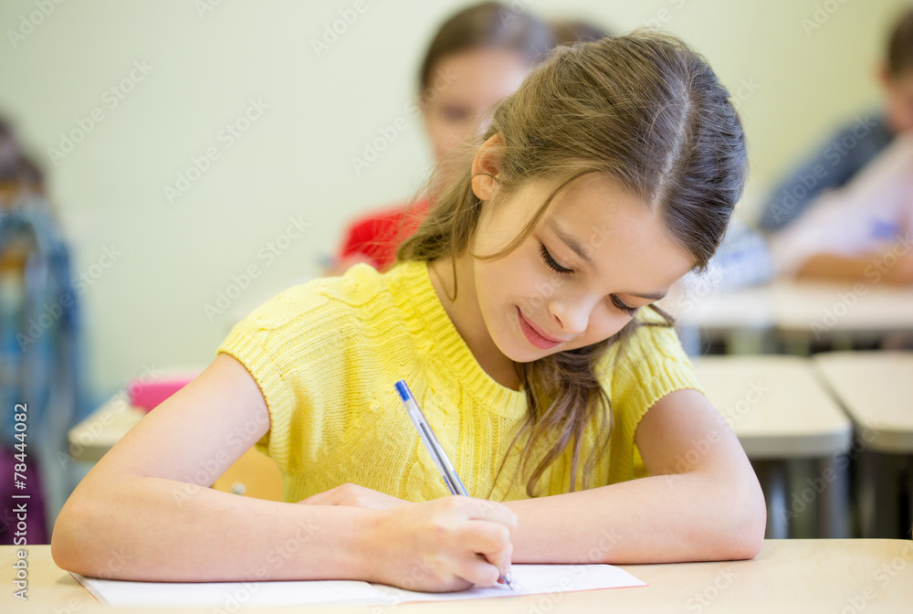 group of school kids writing test in classroom group of school kids writing test in classroom