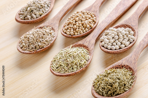 spoons of spices on cutting board