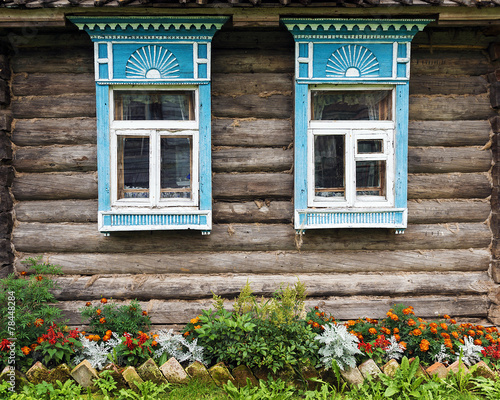 facade of the old wooden houses decorated with flowers #78448284