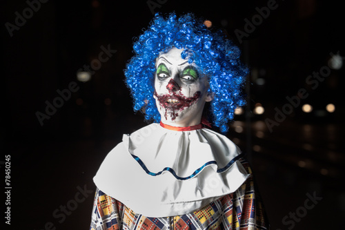 Crazy ugly grunge evil clown on Halloween making people scared