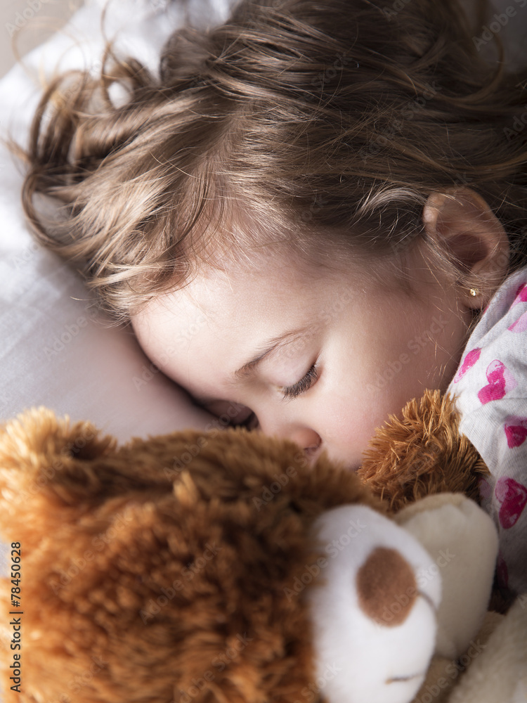 Sweet child sleeping with teddy bear