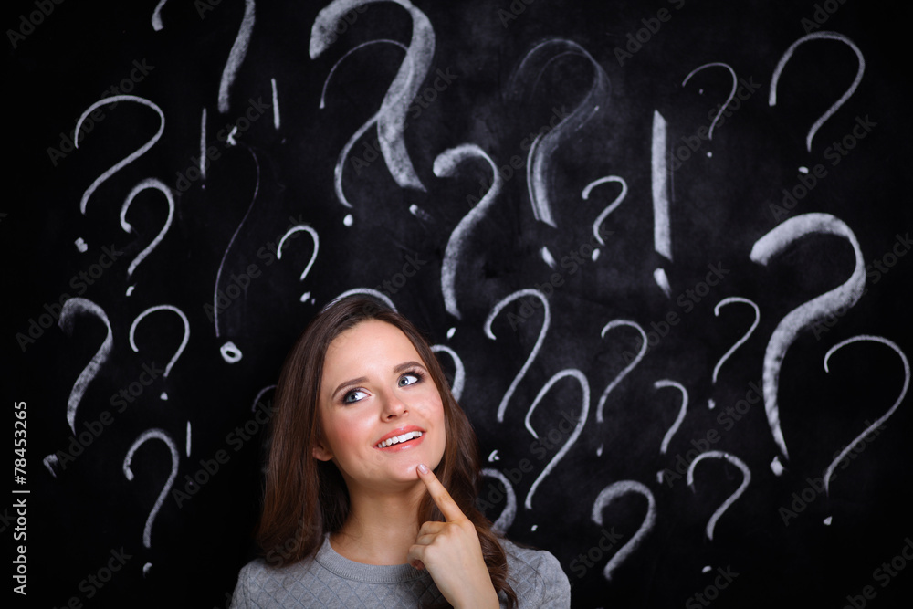 Young girl with question mark on a gray background Young girl with question mark on a gray background