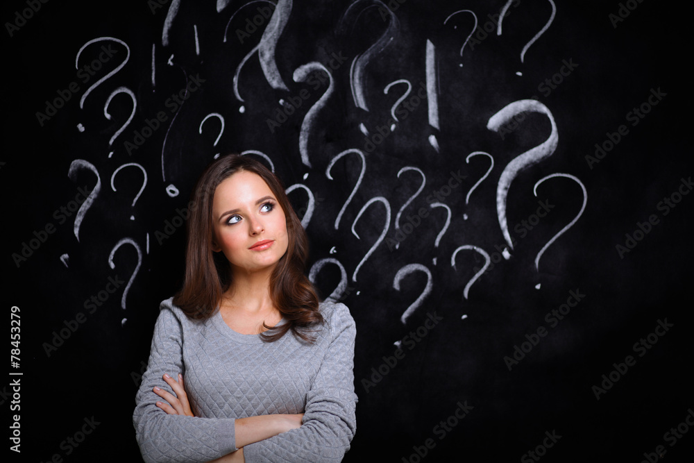 Young girl with question mark on a gray background Young girl with question mark on a gray background