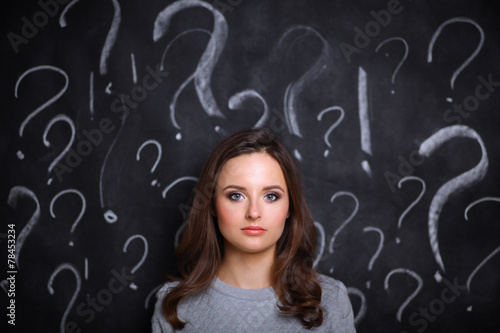 Young girl with question mark on a gray background