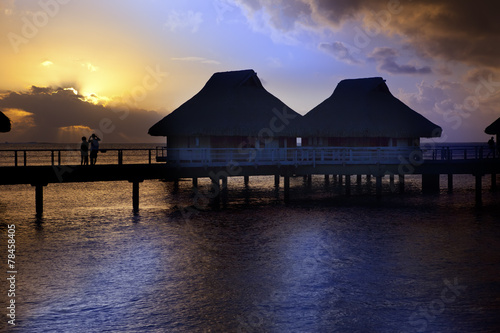 Island in ocean  overwater villas at the time sunset.