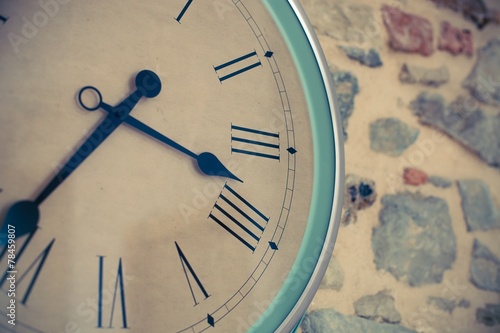 Vintage clock close-up on a stone wall background