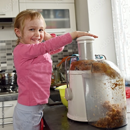 Konstfotografi Happy little girl making fresh apple juice