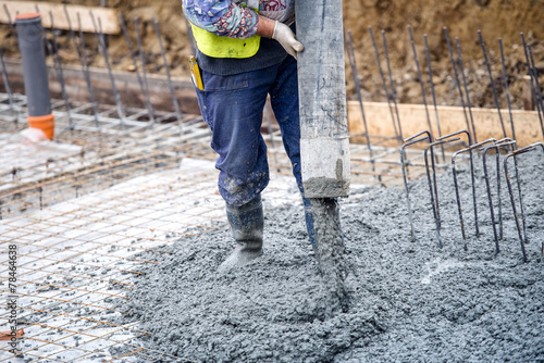 construction worker pouring cement or concrete with pump tube