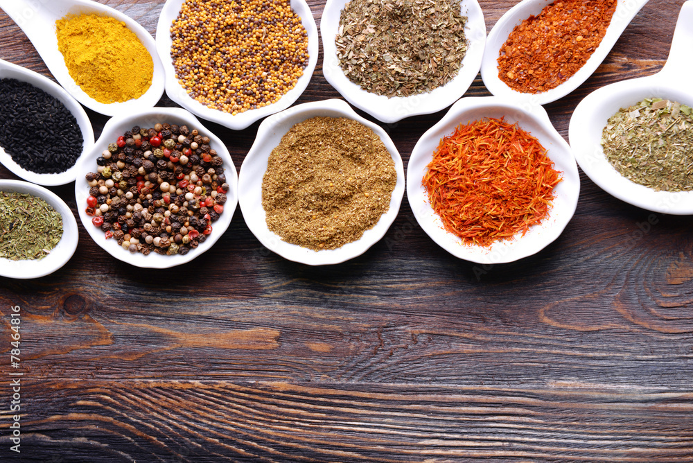 Different kinds of spices in ceramics bowls and spoons Different kinds of spices in ceramics bowls and spoons