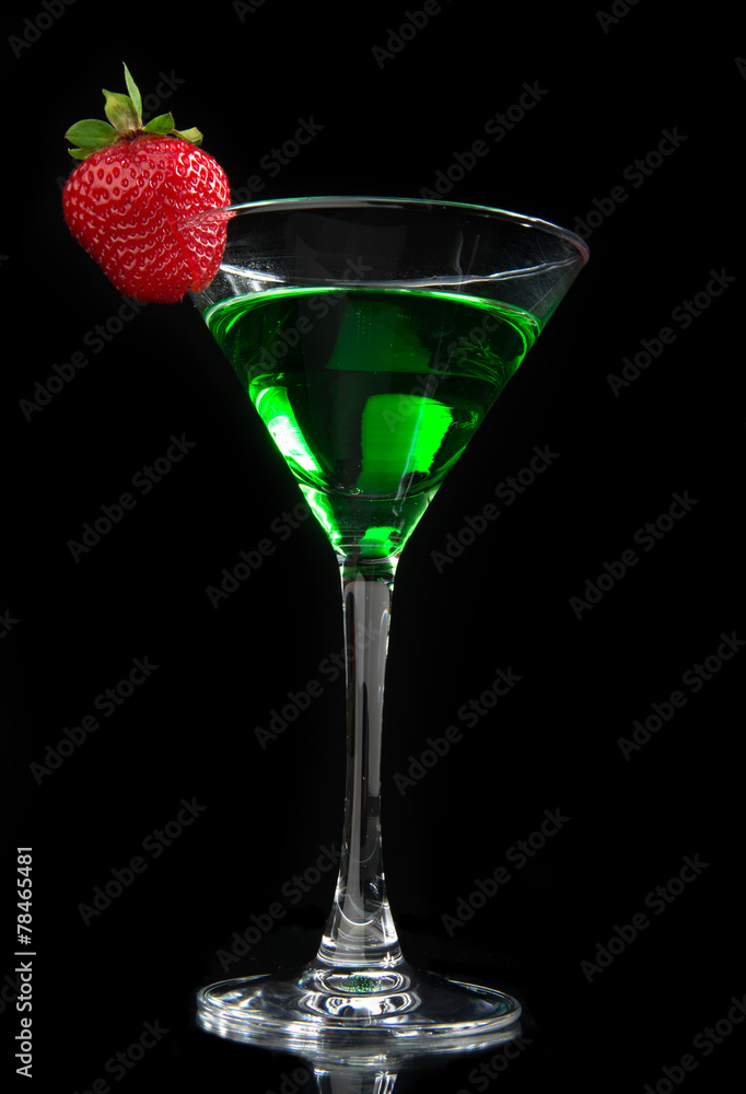 Green cocktail absinth decorated with red strawberry in martini