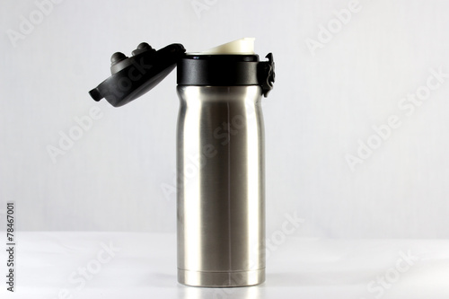 Stainless vacuum bottle cap open on white background