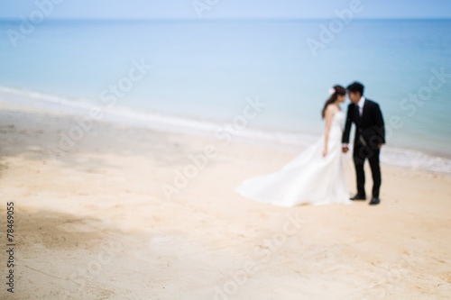 Out of focus of Bride and groom on tropical beach © aradaphotography