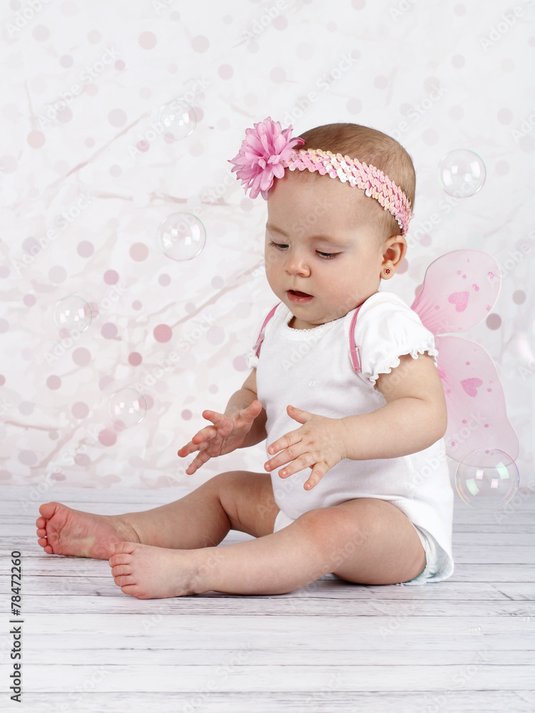 Little baby girl catching bubbles