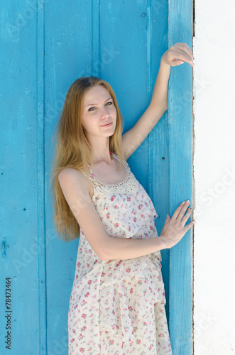 Fashion blonde against the blue door in mykonos island