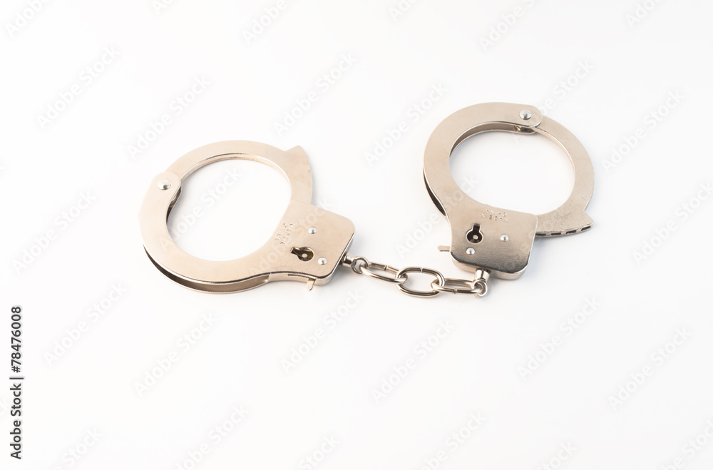 Steel handcuffs on a green background Steel handcuffs on a green background