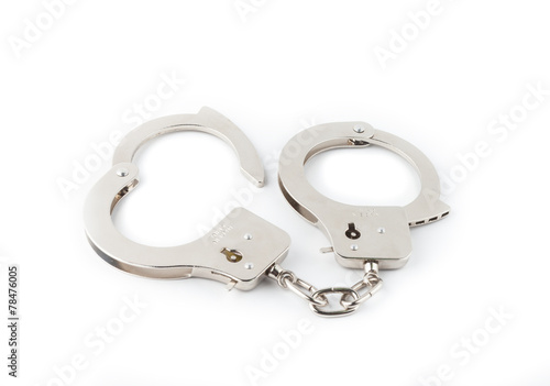 Steel handcuffs on a green background