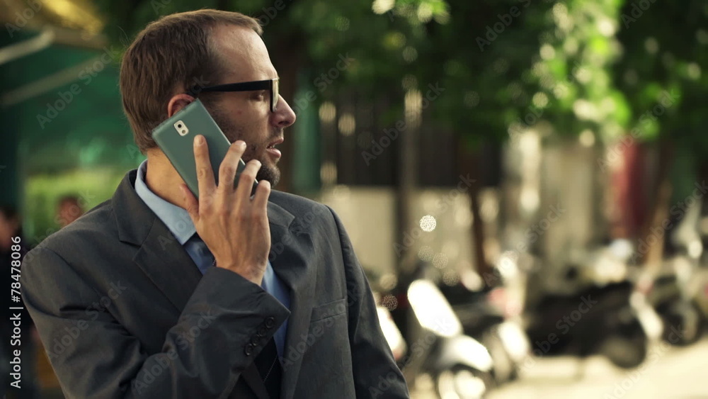 Young, handsome businessman talking on cellphone in city Young, handsome businessman talking on cellphone in city