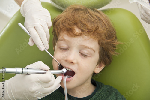 close up of boy having his teeth examined by dentist