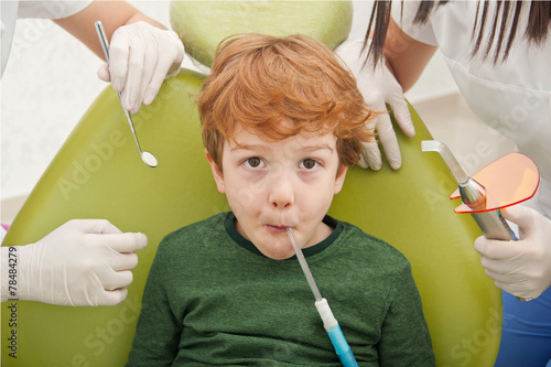 close up of boy having his teeth examined by dentist