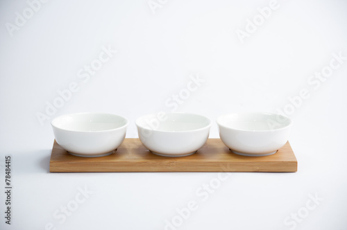 trio of white coffee cups arranged in a row on a wooden tray