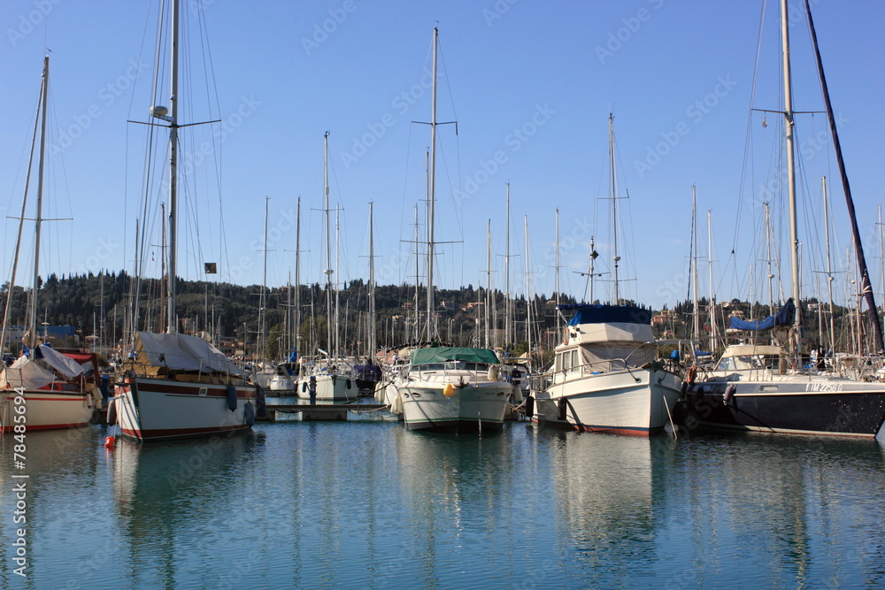 Yachts and sail boats reflected in a Marina	