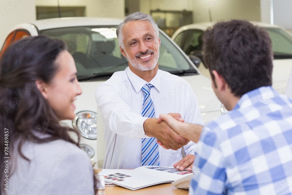 Smiling salesman shaking a customer hand