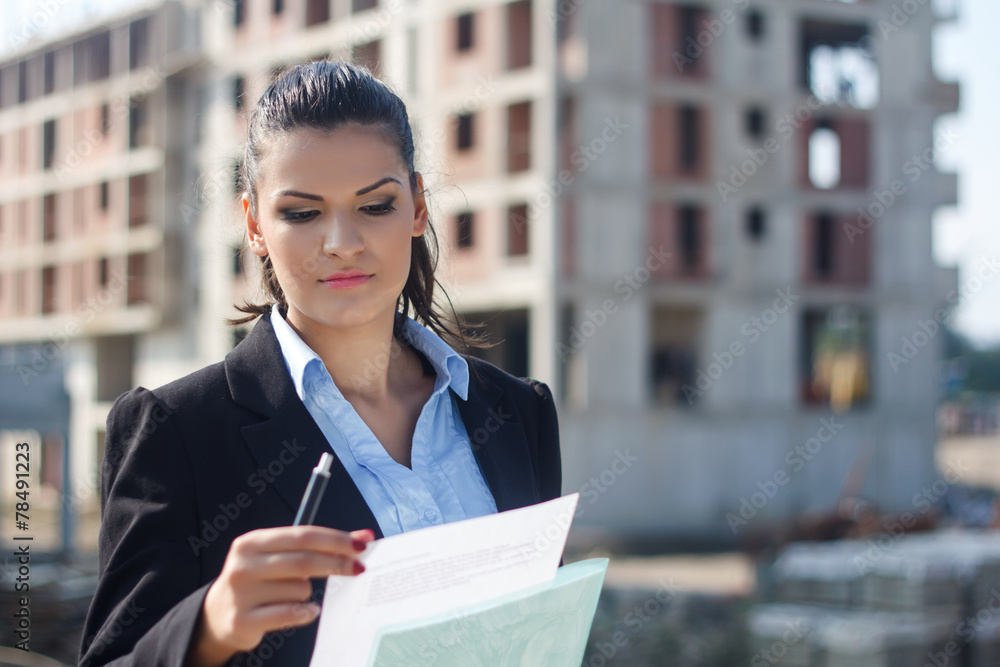Young female architect working at construction site. Young female architect working at construction site.