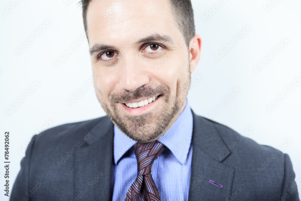 A beautiful business man standing against grey background A beautiful business man standing against grey background