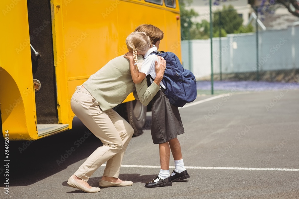 Mother hugging her daughter by school bus Mother hugging her daughter by school bus
