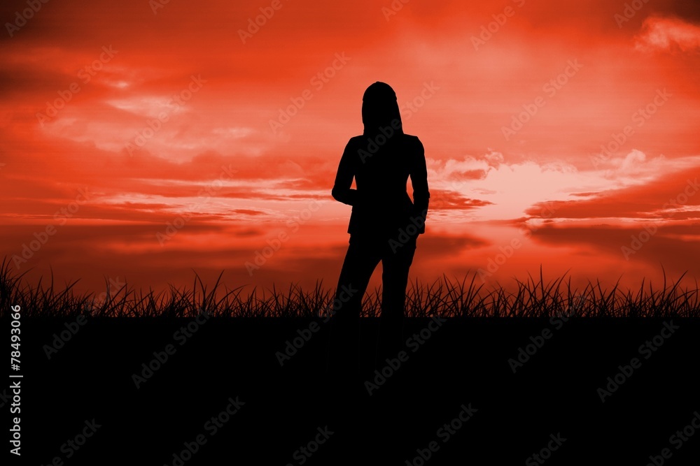 Composite image of silhouette of businesswoman standing