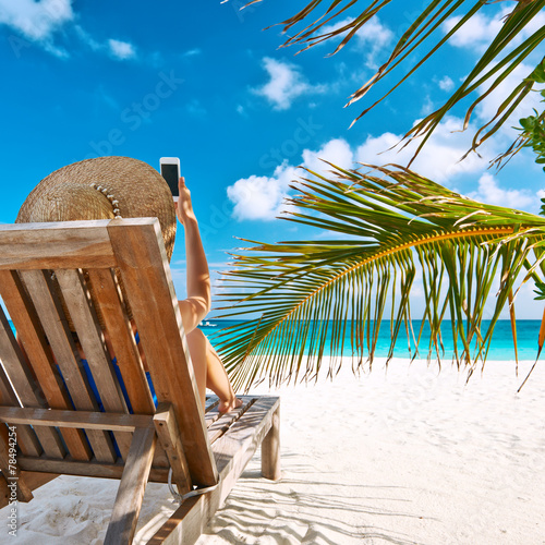 Young woman with mobile phone at the beach