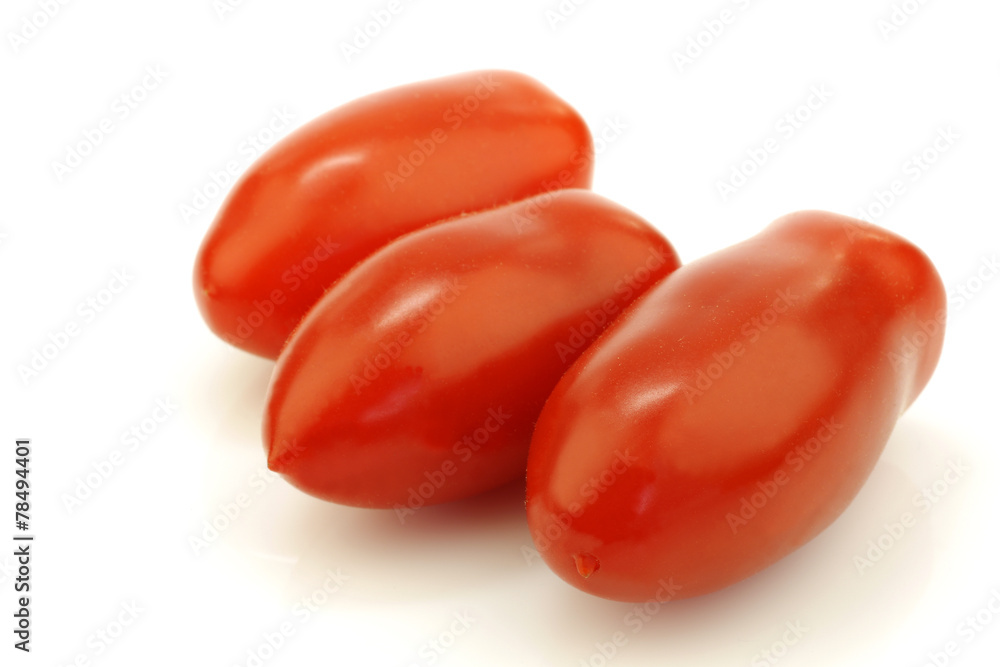 three fresh red italian tomatoes on a white background three fresh red italian tomatoes on a white background