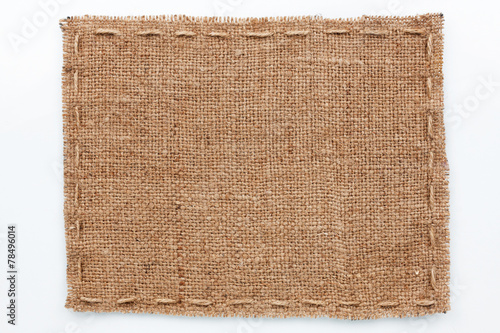 Frame of burlap  lies on a white  background photo