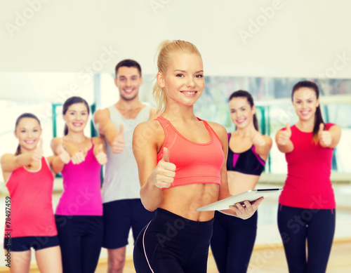 smiling sporty woman with tablet pc computer