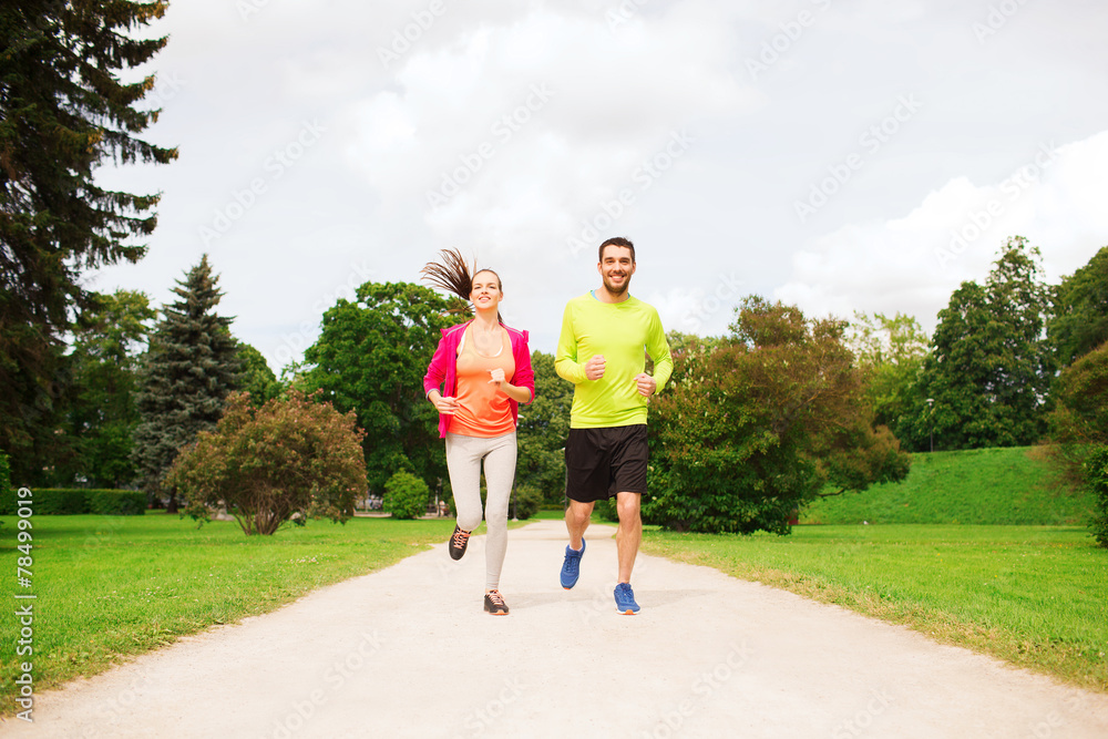 Fototapeta premium smiling couple running outdoors