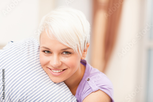 portrait of young blonde woman hugging a pillow