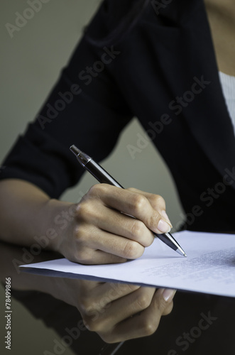 closeup of woman hand signing a contract