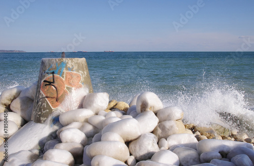 Frozen tetrapod and stones in winter day