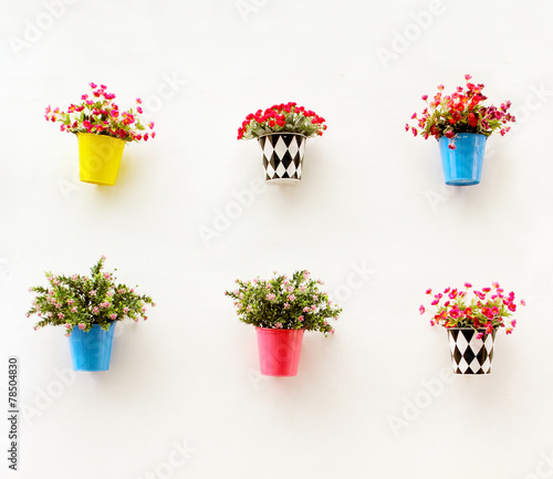 Artificial colorful flowers pots hang onto the wall