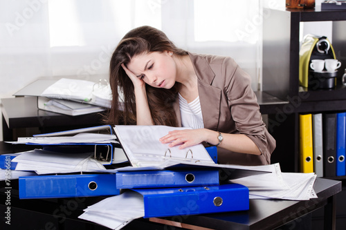Business woman with so many paperwork in the office