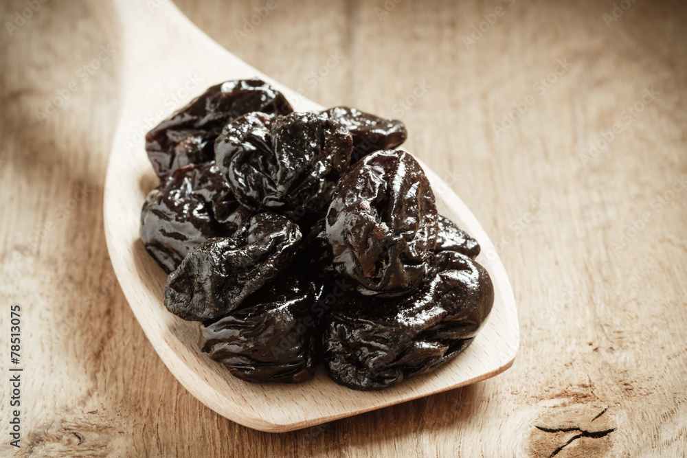 dried plums prunes on wooden spoon dried plums prunes on wooden spoon