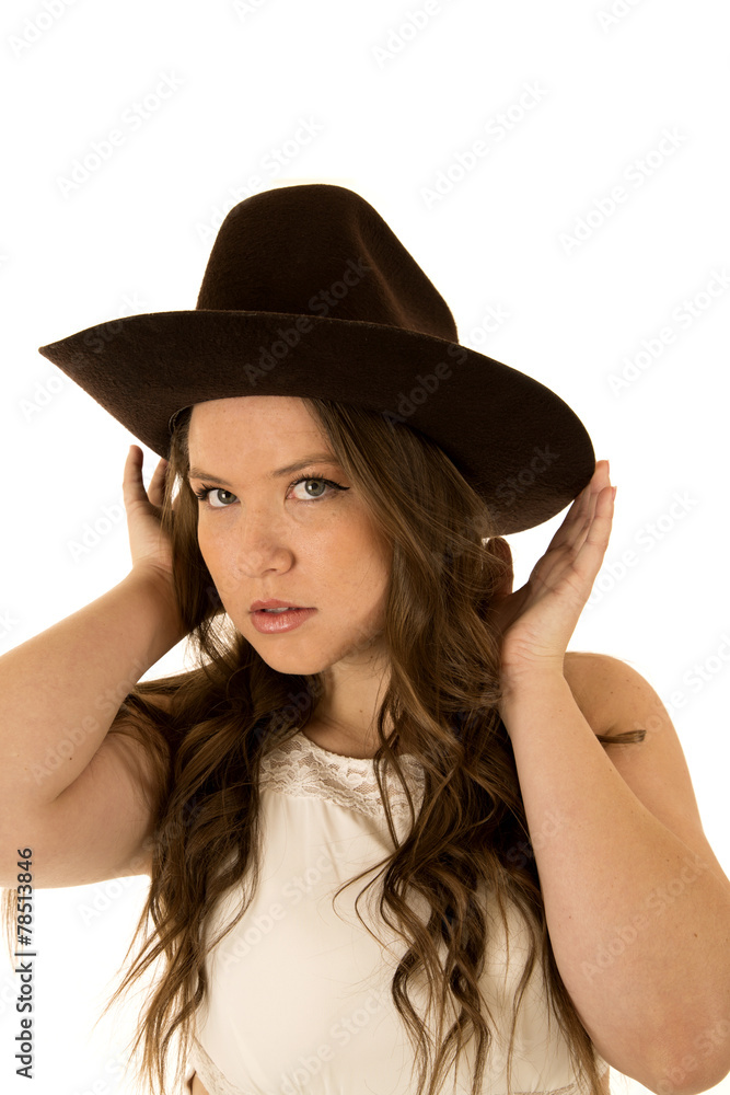 Cowgirl wearing a white dress adjusting her cowboy hat Cowgirl wearing a white dress adjusting her cowboy hat