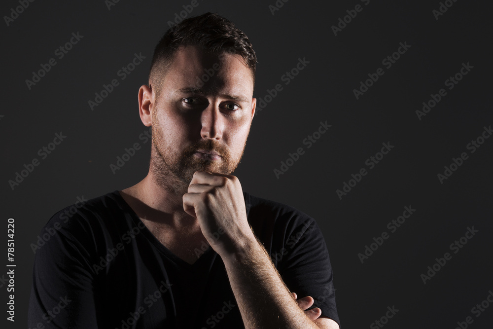 Man posing with dark background and hard lighting Man posing with dark background and hard lighting