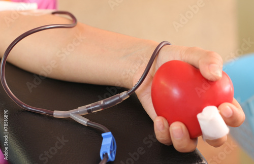 Volunteer young man donor blood close-up shot Several people choose to hold a red heart-shaped ball in the donor's blood in a hospital to help a human being..