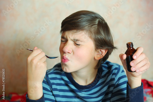 preteen handsome boy make a grimace after taking bitter medicine