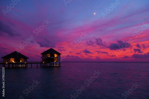 Sunset in the Maldives with a view of the lagoon and bungalows © fazeful
