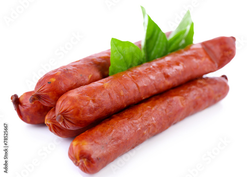 Smoked thin sausages  with basil leaves, isolated on white