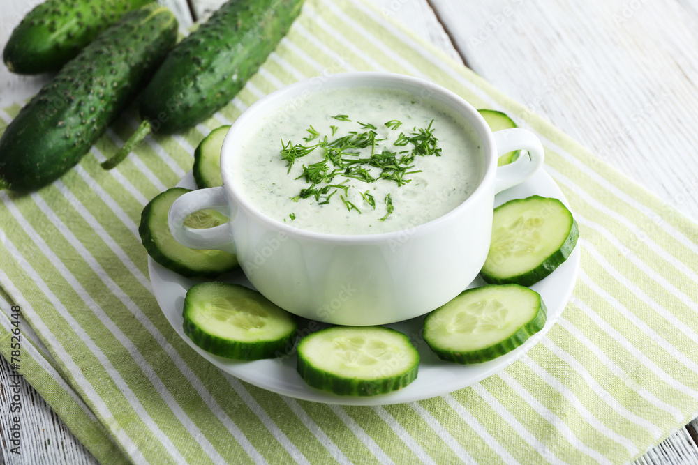 Cucumber soup in bowl on color wooden table background Cucumber soup in bowl on color wooden table background