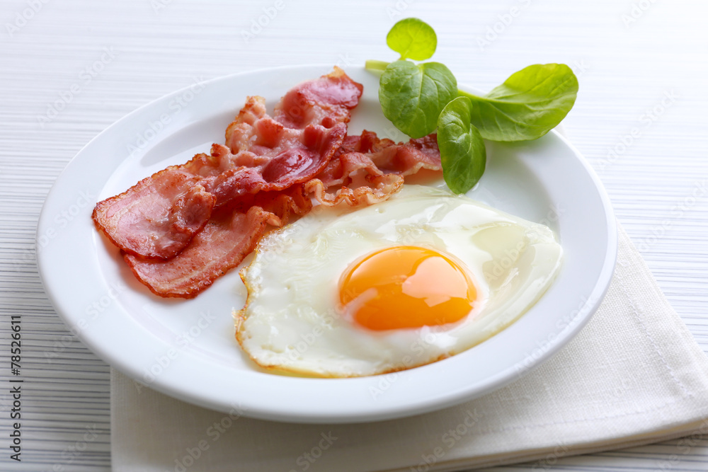 Bacon and eggs on color wooden table background Bacon and eggs on color wooden table background